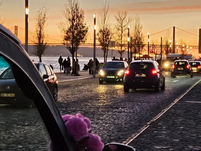 A convoy of electric tuk-tuks on a Lisbon street at sunset