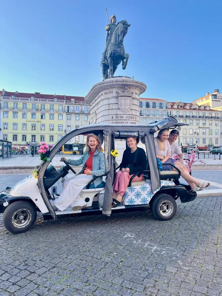 Turistas felices en un tour en tuk-tuk eléctrico por Lisboa