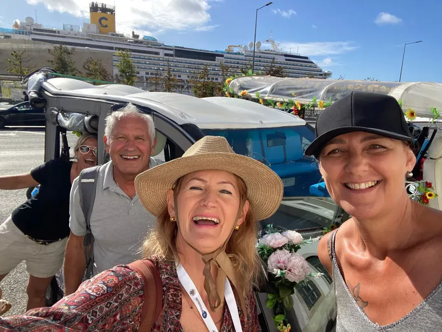Grupo junto ao tuk-tuk florido no terminal de cruzeiros de Lisboa, com o navio atrás